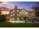 Backyard at dusk features a brick facade, screened porch, patio with seating, and manicured lawn at 2431 Valhalla Ne Dr, Atlanta, GA 30345