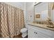 Elegant bathroom featuring granite countertops, a decorative mirror, and a patterned shower curtain at 2431 Valhalla Ne Dr, Atlanta, GA 30345