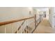 Second floor hallway with carpet flooring and wood railing overlooking staircase at 2431 Valhalla Ne Dr, Atlanta, GA 30345