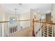 Bright hallway with wooden railing, carpet, and view of the front door and outdoor greenery through a large window at 2431 Valhalla Ne Dr, Atlanta, GA 30345