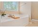 Bathroom featuring a large soaking tub and linen closet, complemented by a neutral color scheme at 2521 Capella Sw Cir, Atlanta, GA 30331