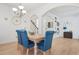 Bright dining area with blue upholstered chairs, light wood table, and modern chandelier at 2521 Capella Sw Cir, Atlanta, GA 30331