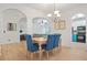 Bright dining area with blue upholstered chairs, light wood table, and modern chandelier at 2521 Capella Sw Cir, Atlanta, GA 30331