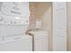 Bright laundry room with stacked washer/dryer, utility sink, and storage at 2521 Capella Sw Cir, Atlanta, GA 30331