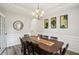 Elegant dining room with a long table, decorative wall art, and a modern chandelier at 2615 Springmonte Pl, Cumming, GA 30041