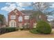 Beautiful two-story brick home featuring a manicured lawn and mature landscaping at 2615 Springmonte Pl, Cumming, GA 30041