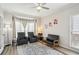 A cozy living room with a ceiling fan, natural light, comfortable seating, and an area rug at 2615 Springmonte Pl, Cumming, GA 30041