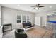 Inviting living room featuring updated flooring, a ceiling fan, large windows, and modern furnishings at 2615 Springmonte Pl, Cumming, GA 30041