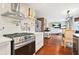 Open-concept kitchen with stainless steel appliances, island cooktop, hardwood floors, and dining area at 4831 Lake Park Ter, Acworth, GA 30101