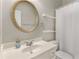 A bathroom with a gold circular mirror above the white sink and vanity at 612 Vinings Estates Se Dr # B12, Smyrna, GA 30126