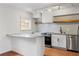 Contemporary kitchen with stainless steel appliances, tile backsplash, and eat-in island at 1235 Woodland Ne Ave # 1, Atlanta, GA 30324