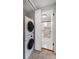 Laundry area with stacked washer and dryer, with a view of the updated bathroom at 1235 Woodland Ne Ave # 1, Atlanta, GA 30324