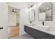 Modern bathroom with a double sink vanity, sleek fixtures, and view of the primary bedroom at 1355 Lockwood Sw Dr, Atlanta, GA 30311