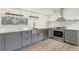 Modern kitchen featuring gray cabinets, stainless steel appliances, hardwood floors, and natural light at 1355 Lockwood Sw Dr, Atlanta, GA 30311
