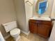 This bathroom includes a toilet, vanity with sink, and an oval mirror at 371 Landers Sw Dr, Mableton, GA 30126