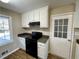 Kitchen featuring white cabinets, sleek black appliances, and wood-look flooring at 371 Landers Sw Dr, Mableton, GA 30126
