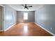 An empty bedroom with hardwood floors, a window, and a ceiling fan with a light fixture at 37 Indian Hills Ct, Dallas, GA 30157
