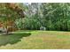 Expansive backyard with mature trees, shed and lush grass providing ample space for recreation and relaxation at 4184 Wyndham Park Way, Buford, GA 30519