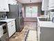 This kitchen has stainless steel appliances, white cabinets, tile floors, and a white countertop at 4184 Wyndham Park Way, Buford, GA 30519