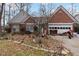 All-brick single-story home with a two-car garage and landscaping in need of some care at 1220 Tab Roberts Rd, Lawrenceville, GA 30043