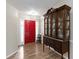 Welcoming foyer with a red front door, hardwood floors, and an antique cabinet at 1220 Tab Roberts Rd, Lawrenceville, GA 30043