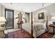 Elegant bedroom with a four-poster bed, antique furnishings, and a balcony offering city views at 145 15Th Ne St # 843, Atlanta, GA 30309
