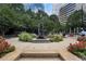 Serene public park featuring a water fountain, lush greenery, and vibrant flower beds at 145 15Th Ne St # 843, Atlanta, GA 30309