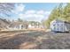 Large, grassy backyard featuring a storage shed, surrounded by mature trees and greenery at 1925 Meyers Dr, Lawrenceville, GA 30045
