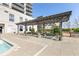 Inviting poolside area featuring a pergola, seating, and lush landscaping for relaxing or entertaining guests at 2277 Peachtree Ne Rd # 608, Atlanta, GA 30309