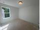 A bright, minimalist bedroom with a large window overlooking trees and a sunlit floor at 630 Gilles Ln, Cumming, GA 30041