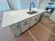 Close-up of the kitchen island featuring a sink, quartz countertops, and stylish cabinetry at 630 Gilles Ln, Cumming, GA 30041