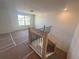 Open landing area with natural light, wooden railing with black spindles, and view of neighborhood from the window at 630 Gilles Ln, Cumming, GA 30041