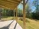 View from the patio showcasing the timber beam construction and spacious backyard with treeline at 630 Gilles Ln, Cumming, GA 30041
