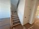 Interior view of a staircase featuring modern wooden steps, contrasting dark railing, and a convenient storage closet at 630 Gilles Ln, Cumming, GA 30041