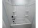 Clean white tub/shower combination with shelving at 630 Gilles Ln, Cumming, GA 30041