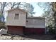 View of back of house with large red brick foundation and siding at 2061 Detroit Nw Ave, Atlanta, GA 30314