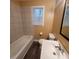 Cozy bathroom featuring a tiled shower-tub, updated vanity, and wood-look flooring at 2061 Detroit Nw Ave, Atlanta, GA 30314