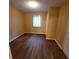 A small bedroom with wood floors, one window, and a single overhead light at 2061 Detroit Nw Ave, Atlanta, GA 30314