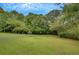 Manicured backyard with lush green grass and mature trees and plant life at 12040 Old Mountain Park Rd, Roswell, GA 30075