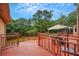 Backyard wooden deck with railings and furniture is surrounded by lush trees and nature at 12040 Old Mountain Park Rd, Roswell, GA 30075