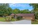Charming single-story home with lush lawn, mature trees, and welcoming pergola over stone planter bed at 12040 Old Mountain Park Rd, Roswell, GA 30075