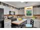 Well-lit kitchen featuring granite countertops, white cabinets, an island, and stainless steel appliances at 12040 Old Mountain Park Rd, Roswell, GA 30075