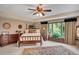 Spacious bedroom featuring a four poster bed, sitting area, and a large window at 12040 Old Mountain Park Rd, Roswell, GA 30075