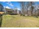 Spacious backyard with mature trees, a well-maintained lawn, and partial view of the home's rear exterior at 1532 Boxwood Nw Trce, Acworth, GA 30102