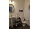 Cozy half bathroom with pedestal sink, toilet, and dark floors, decorated with modern black accents at 3671 Casual Ridge Way, Loganville, GA 30052
