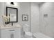 Modern bathroom features white marble-style tile, a vanity with black fixtures, and a glass-enclosed shower at 7608 Parkland Bnd, Fairburn, GA 30213