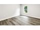 This bedroom features a window and beautiful gray wood flooring at 7608 Parkland Bnd, Fairburn, GA 30213