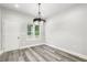 Bright dining room featuring a stylish chandelier and light grey wood-look floors at 7608 Parkland Bnd, Fairburn, GA 30213