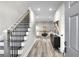 Inviting entryway featuring hardwood floors, staircase with modern black railings, and ample lighting at 7608 Parkland Bnd, Fairburn, GA 30213