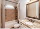 Bathroom features a granite counter, framed mirror, tub and shower with tile surround and small arched window at 1837 Haven Park Se Cir, Smyrna, GA 30080